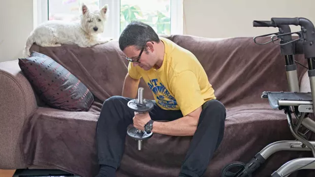 Man with ms exercising at home with dumbells