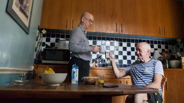 Photo: Men sat in kitchen