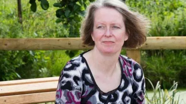 A woman staring into the distance on an outdoor bench, representing how MS can affect mental health.