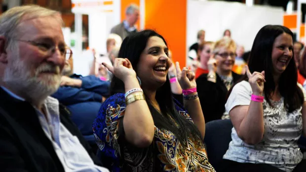 Three people enjoying an event smiling 