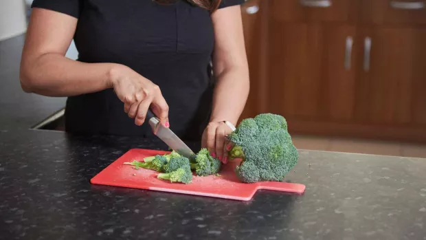 Photo: Woman chopping broccoli in the kitchen