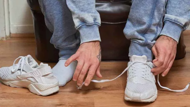a photo of a man Tying shoe laces