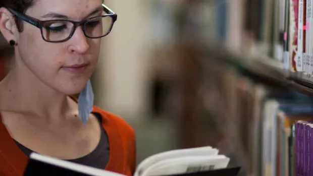 Photo: Woman with MS reading in the library