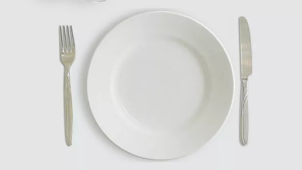 a photo of an empty plate with knife and fork