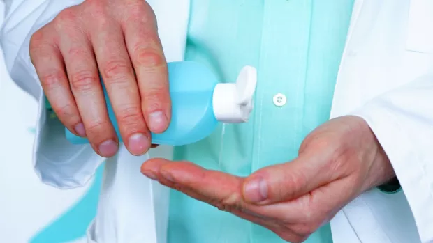 A photo showing the hands of a Clinician with antibacterial gel