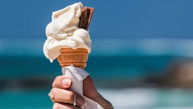 Photo:Close up of a hand holding an ice cream in the sunshine.