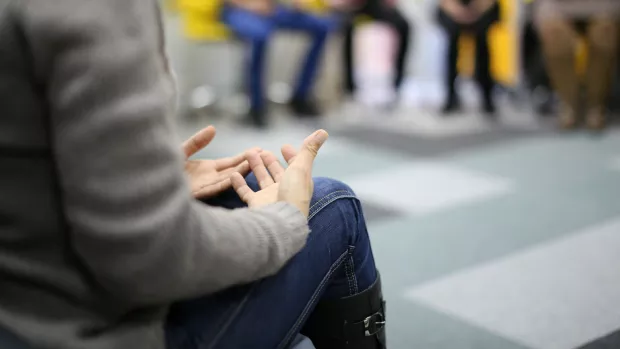 A group of people sit on chairs in a circle