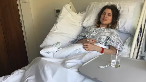 Edith in a hospital bed in a ward