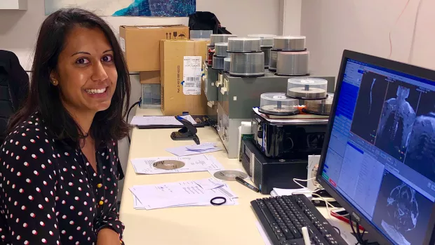 Anisha sits at her computer at work