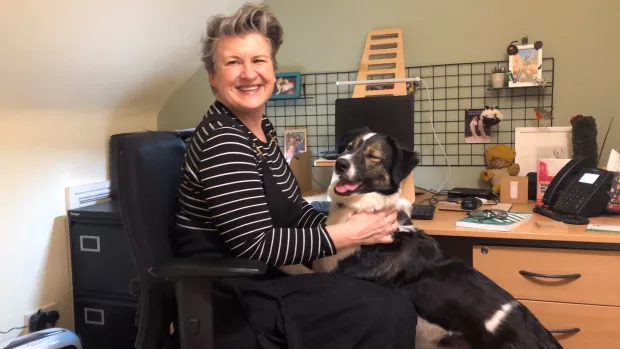 Danielle in her home office with her dog