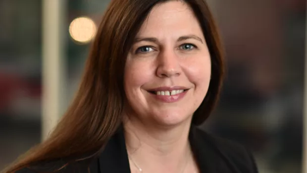 Head and shoulders portrait of Dr Sarah Rawlings facing the camera smiling