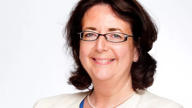 Professor Parvitt stands against a white background. She has shoulder length brown hair, is wearing glasses and is smiling.