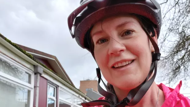 Head shot of Em wearing a cycling helmet and smiling