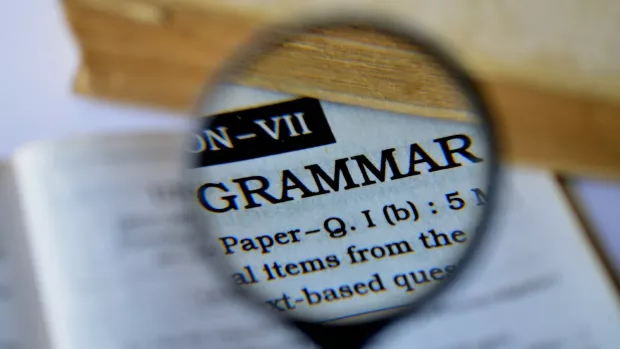 a magnifying glass brings into focus the word 'grammar'
