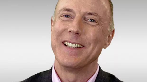 head shot of a man in a dark blazer and lavender shirt