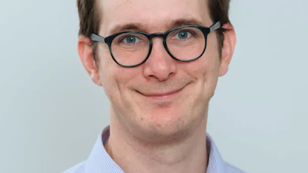 Dr David Hunt, a man with short brown hair and dark rimmed glasses wearing a blue shirt
