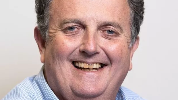 Neil Forbes. A smiling man in a blue and white striped shirt. 