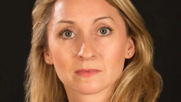 Dr Rachel Farrell, head shot of a woman with green eyes and blonde hair