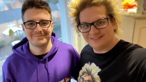 Photo of Mark and his boyfriend Mart. Mark is wearing a purple Game Over for MS hoodie.