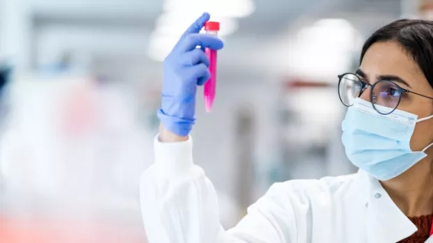 Researcher using a centrifuge, a piece of equipment used to spin liquids at high speeds