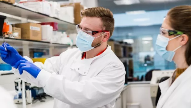 Three researchers looking at a tissue sample
