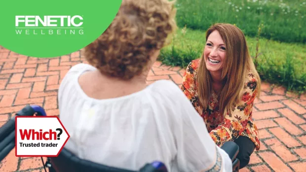 A photo shows a lady in a wheelchair talking to another lady who's smiling.