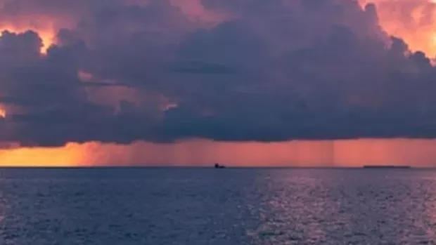 The photo shows a stormy sky above the sea