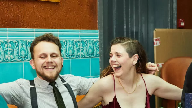 2 white men with beards, a white woman with an undercut and an asian woman laugh together in a social setting