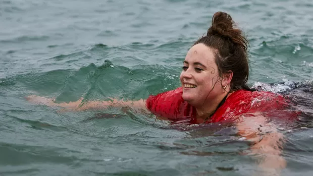 A smiling woman swimming in the sea