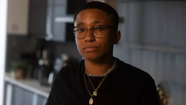 Jay Jay in a kitchen wearing glasses and a black top 