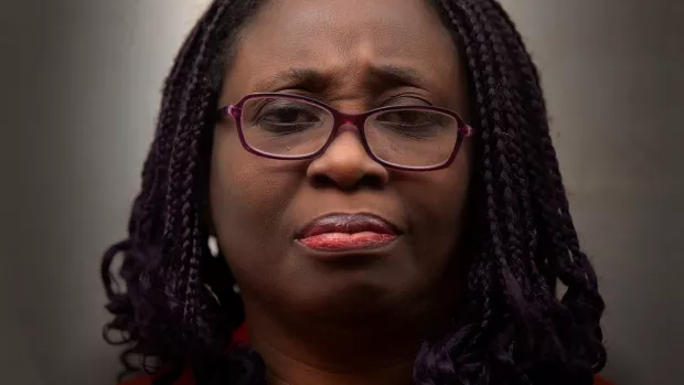 Head shot of Adeyinka looking direct to camera with a serious expression.