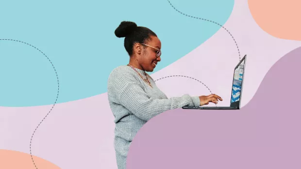 Black woman stands in profile typing into a laptop