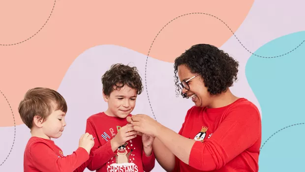 Two children do a craft activity with their mother who is Black