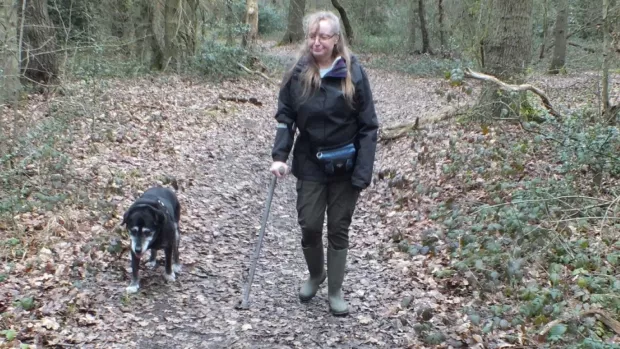 Caroline walking in the woods with her dog