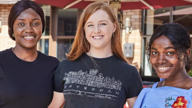 Group of 3 people outside, smiling