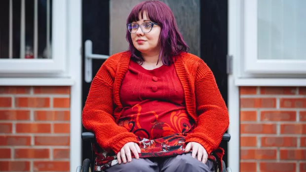 Sabrina outside, wearing a red top