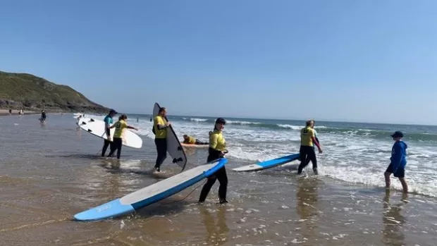 Picture of people carrying surfboards 