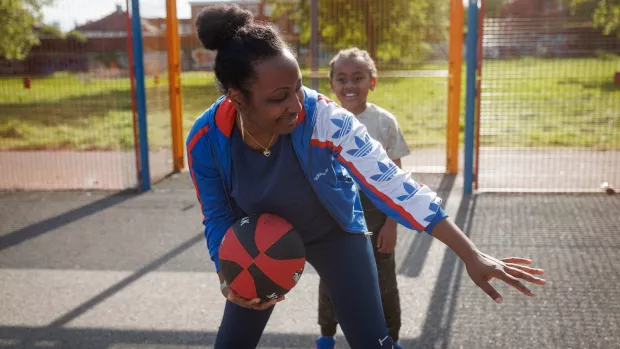 A mother playing basketball with her child