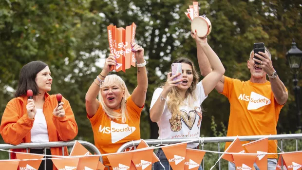 Fundraisers in MS Society t-shirts cheering at a fundraising event