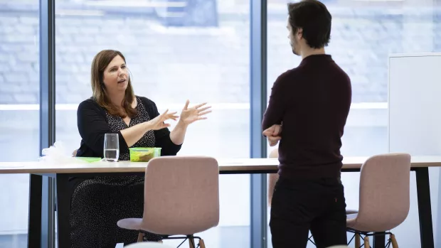 Two members of staff having a discussion at the MS Society office