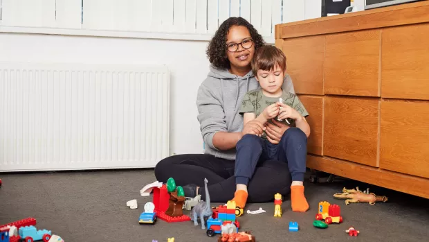 A woman holding her child in her living room