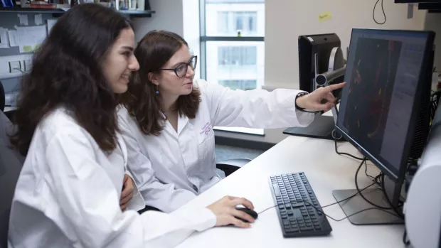 Two researchers having a discussion in front of a computer screen