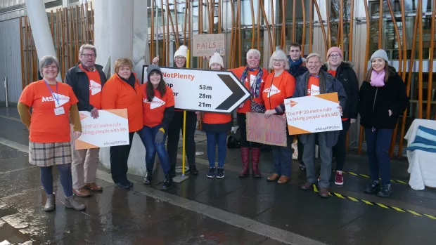  A group of MS Society campaigners holding placards for a PIP campaign