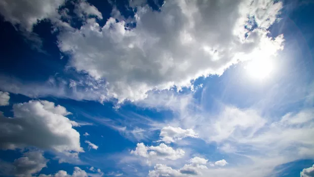 Photo of a blue sky with white clouds and sunshine