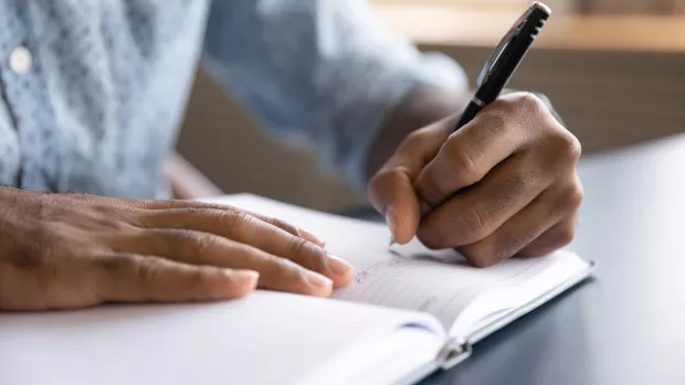 A person writing in a notebook