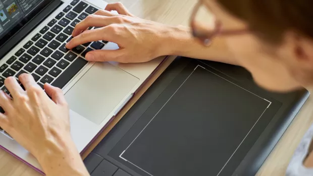  Close up of hands typing on a laptop