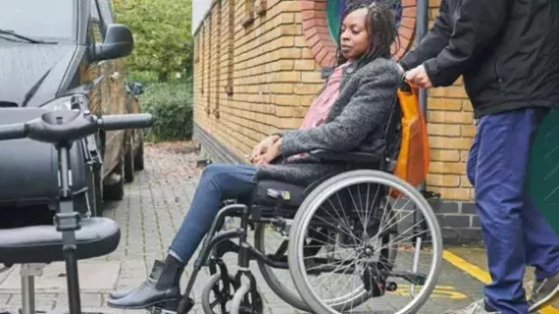 Woman with MS being pushed in a wheelchair