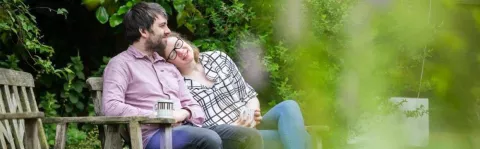 Photo: Young couple sat on bench in garden