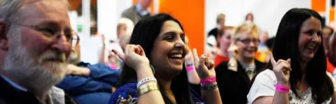 Woman with hands up at MS Society meeting