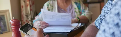 a photo of two women looking at some financial paper work